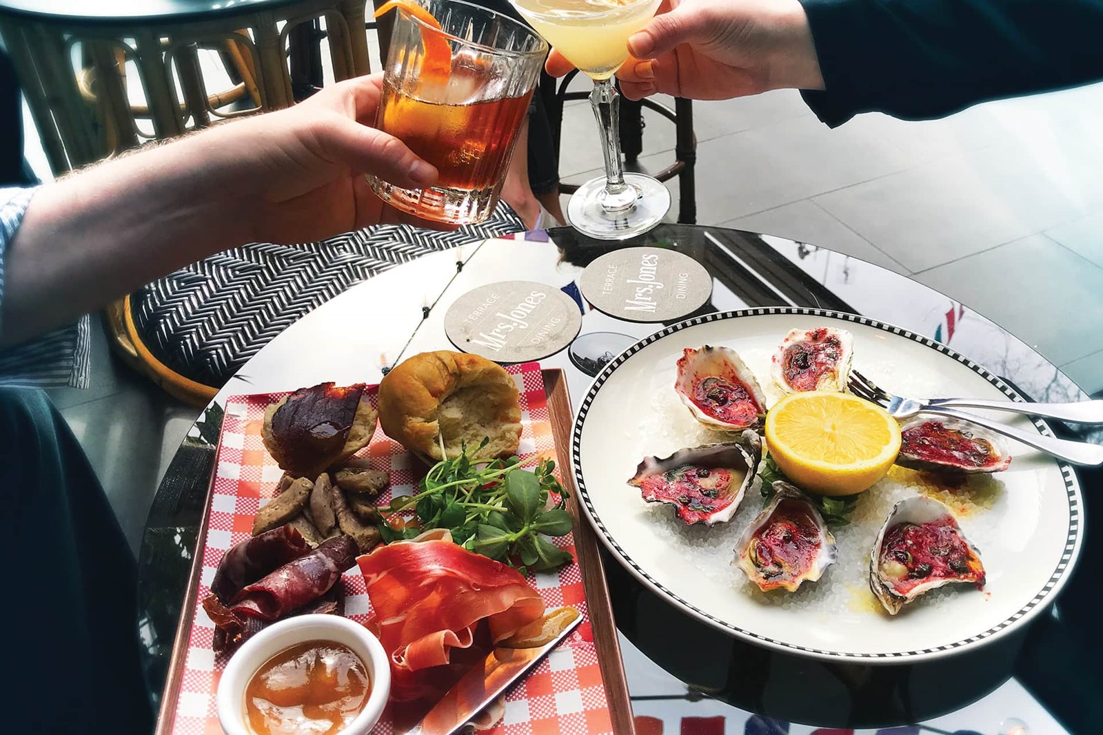Shared plates and drinks on a Mrs Jones terrace table