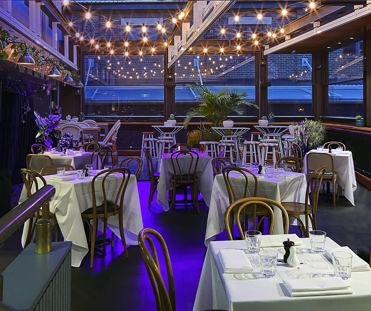 Mrs Jones dining room set for dinner beneath terrace lights